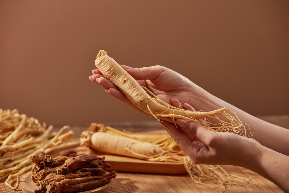 Image,Of,Female,Hand,Holding,Ginseng,Root,On,Brown,Background