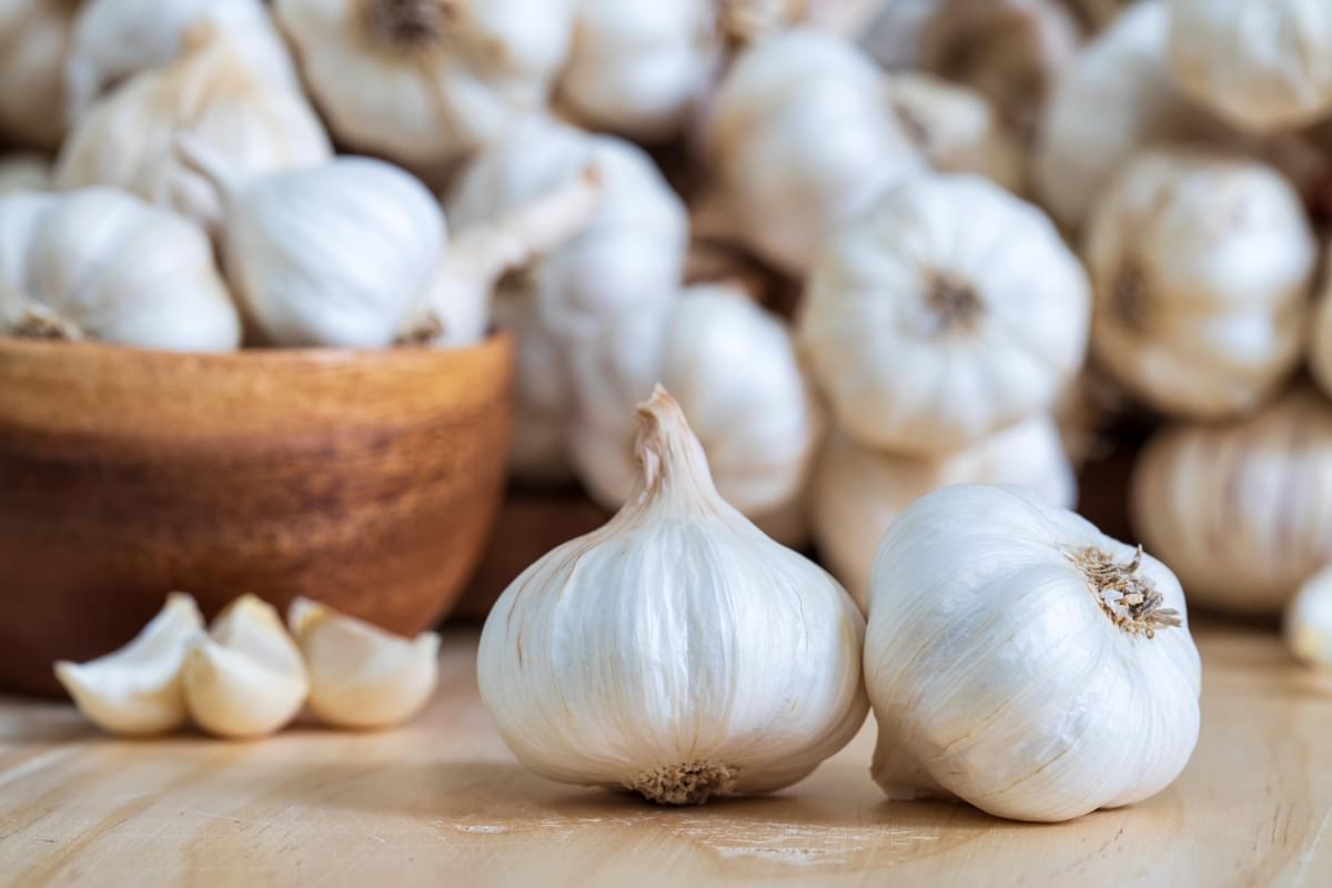 Closeup,Of,Garlic,Bulbs,On,Wooden,Table,With,Garlics,Blur