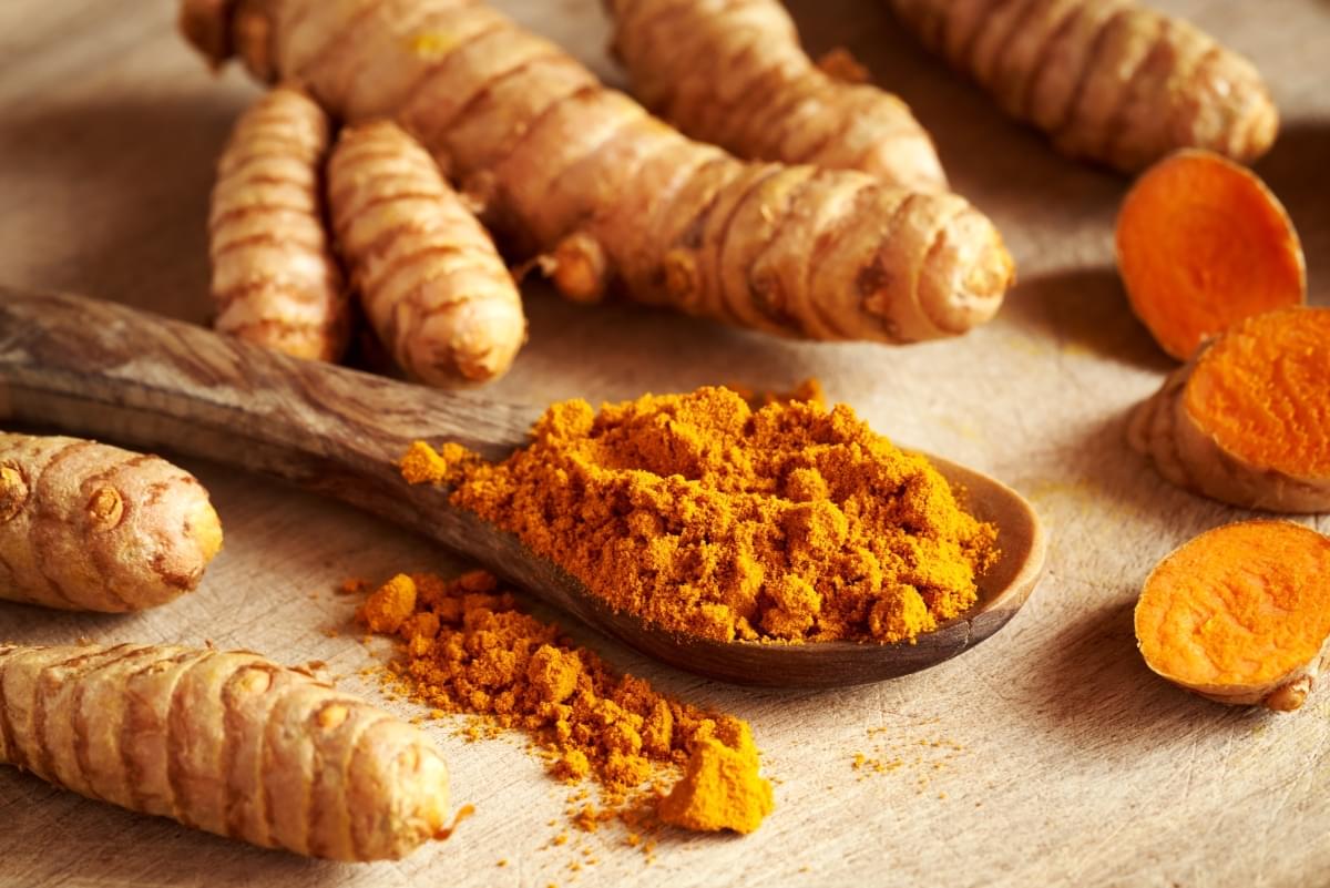 Turmeric,Powder,On,A,Wooden,Spoon,With,Fresh,Whole,And